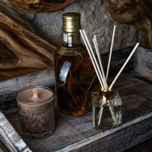 whiskey and caramel σετ που περιλαμβάνει ένα αρωματικό χώρου βανίλια σε διάφανο μπουκαλάκι και ένα κερί με άρωμα ουίσκι και καραμέλα σε κρυστάλλινο ποτήρι, χρώματος μπεζ με ξύλινο φυτίλι